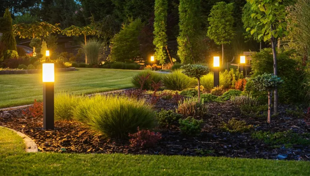 Panoramic Photo of LED Light Posts Illuminating Backyard Garden During Night Hours. 