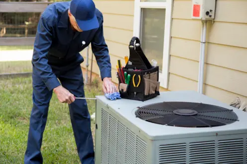 Technician servicing outdoor air conditioning unit for Acosta Heating, Cooling & Electrical.