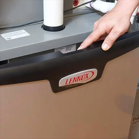 Lennox HVAC unit with access panel, showing inspection by Acosta Heating, Cooling & Electrical professional.