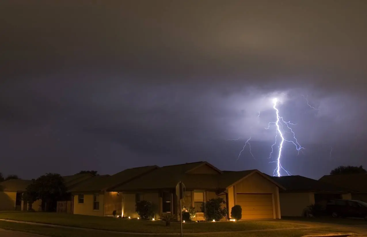 Lightning strikes in the night near residential area