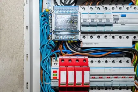 A detailed view of a residential main service panel interior with multiple white toggle switches, terminal blocks, and complex electrical wiring.