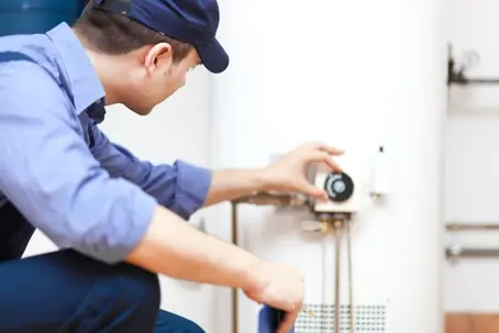 HVAC and plumbing specialist performing routine maintenance and safety checks on a home water heating system.