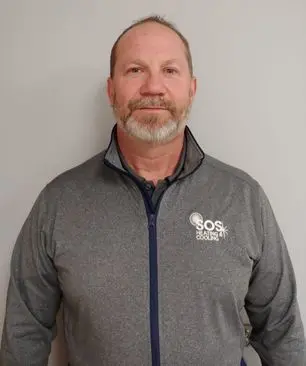 Ken R. wearing SOS Heating & Cooling branded jacket, showcasing expertise in HVAC as Commercial Manager.