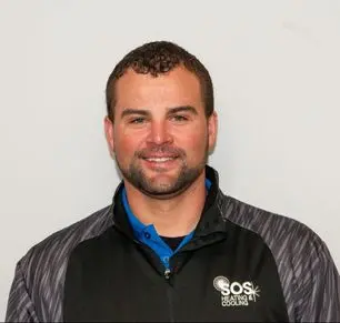 Jon S. wearing SOS Heating & Cooling branded jacket, smiling, showcasing HVAC expertise and commitment to community service.