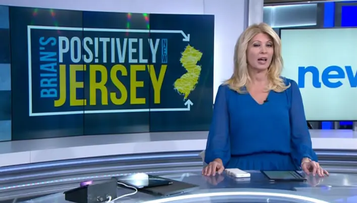 News12 New Jersey broadcast featuring a host discussing community support and charitable acts, with the "Positively New Jersey" logo in the background.
