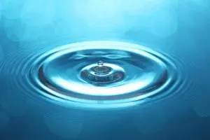 Rippling water surface with a drop creating concentric circles, symbolizing clean water and plumbing services offered by American Eagle Plumbing, Inc.