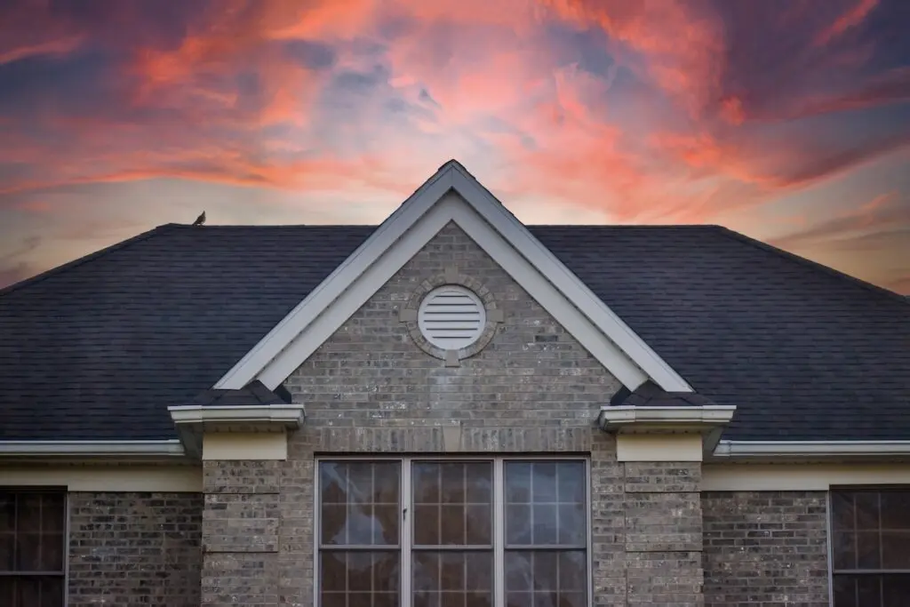 Large brick house with black shingle roof