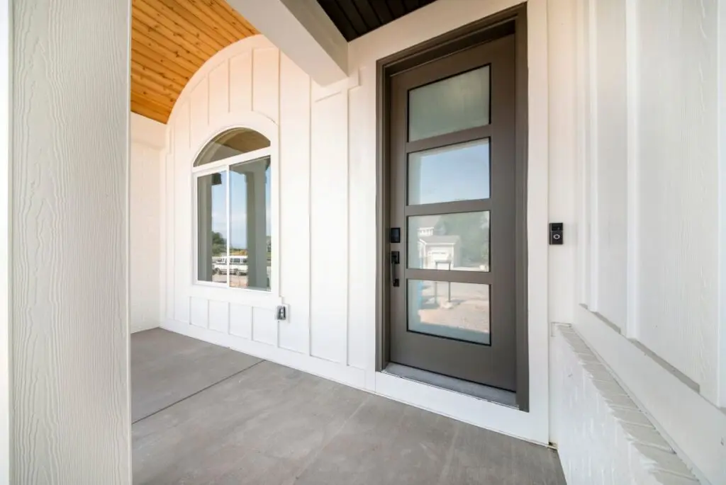 white board and batten siding black door door
