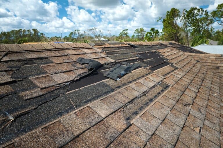 Damaged house roof with missing shingles