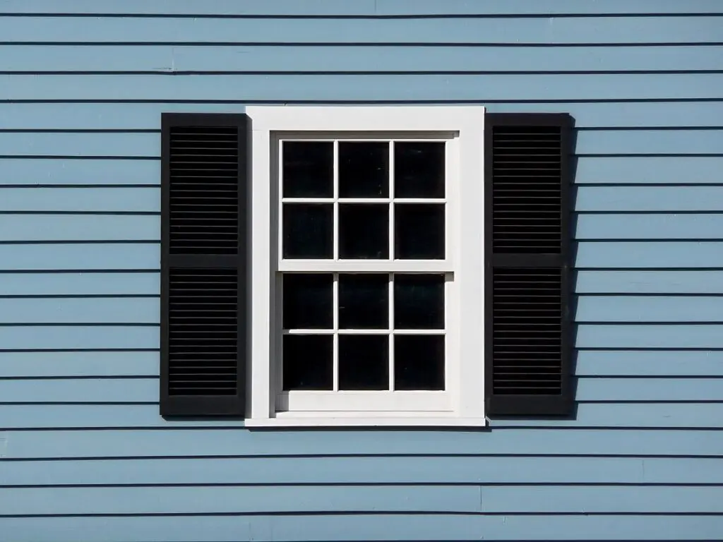 blue house with white window and black accents