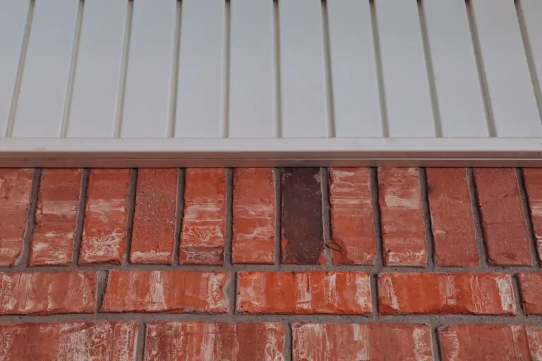 Orange bricks and white vinyl siding