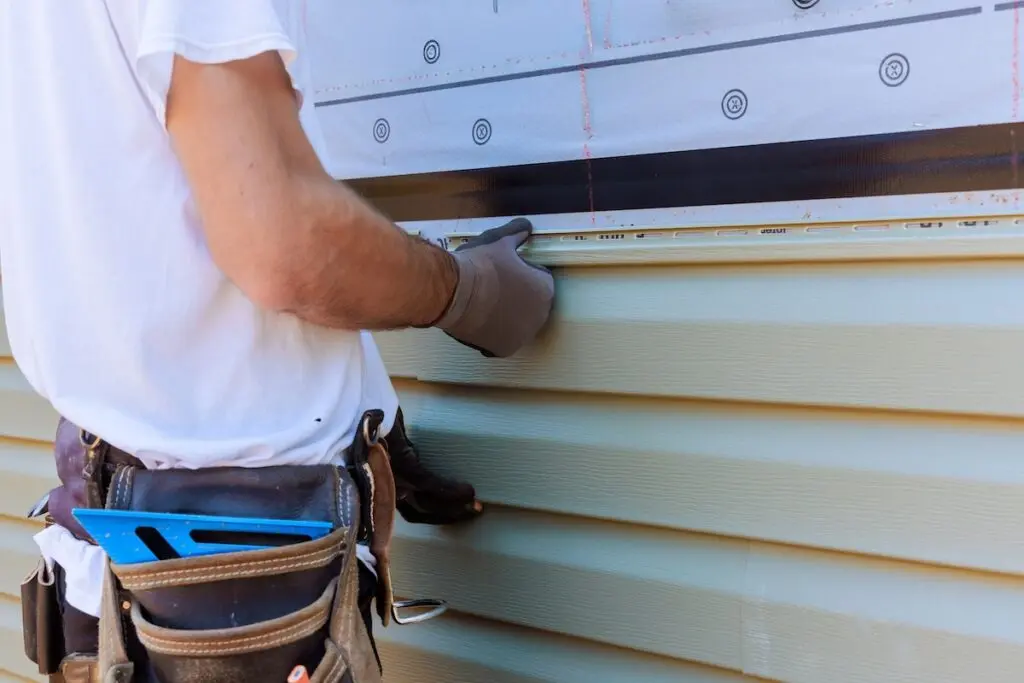Handyman installing vinyl siding