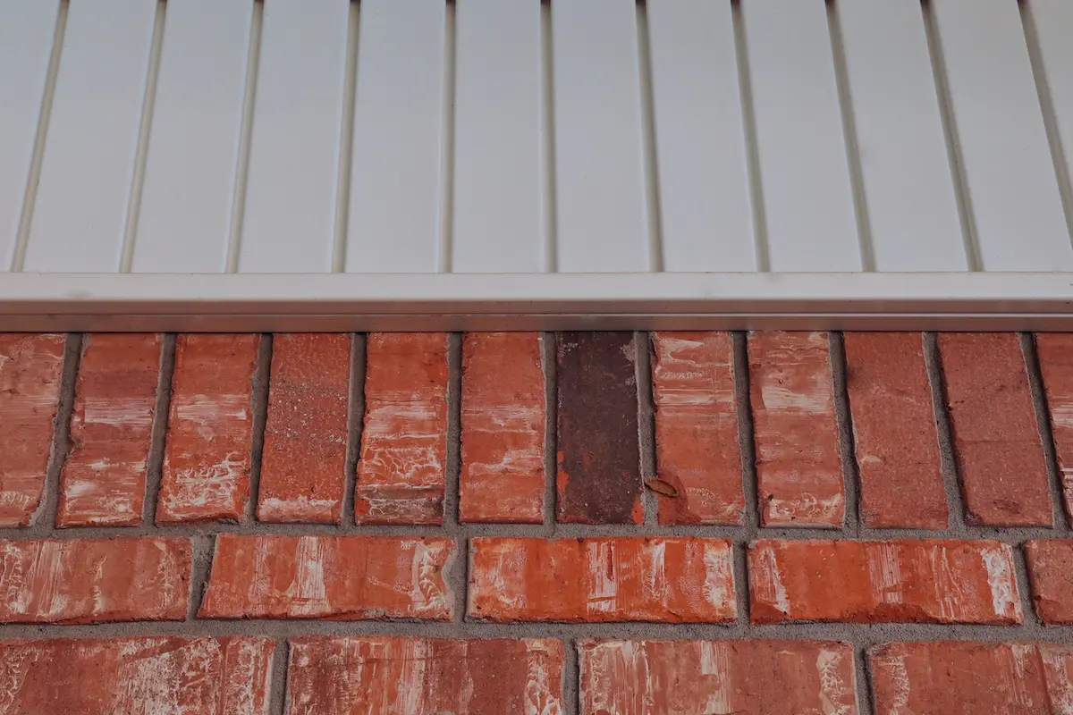 Orange bricks and white vinyl siding