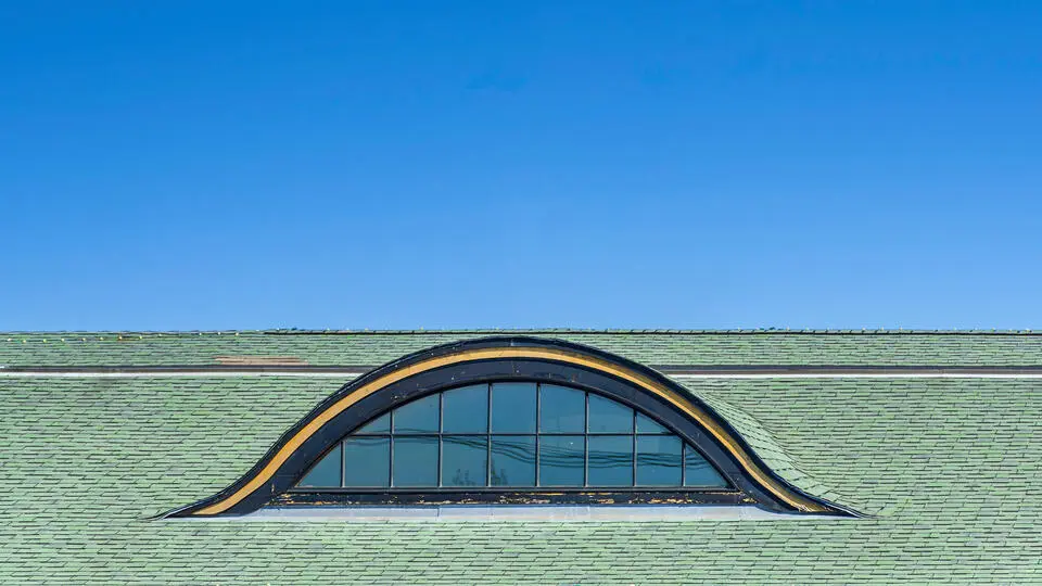 types of dormers-eyebrow curved dormer on green shingle roof