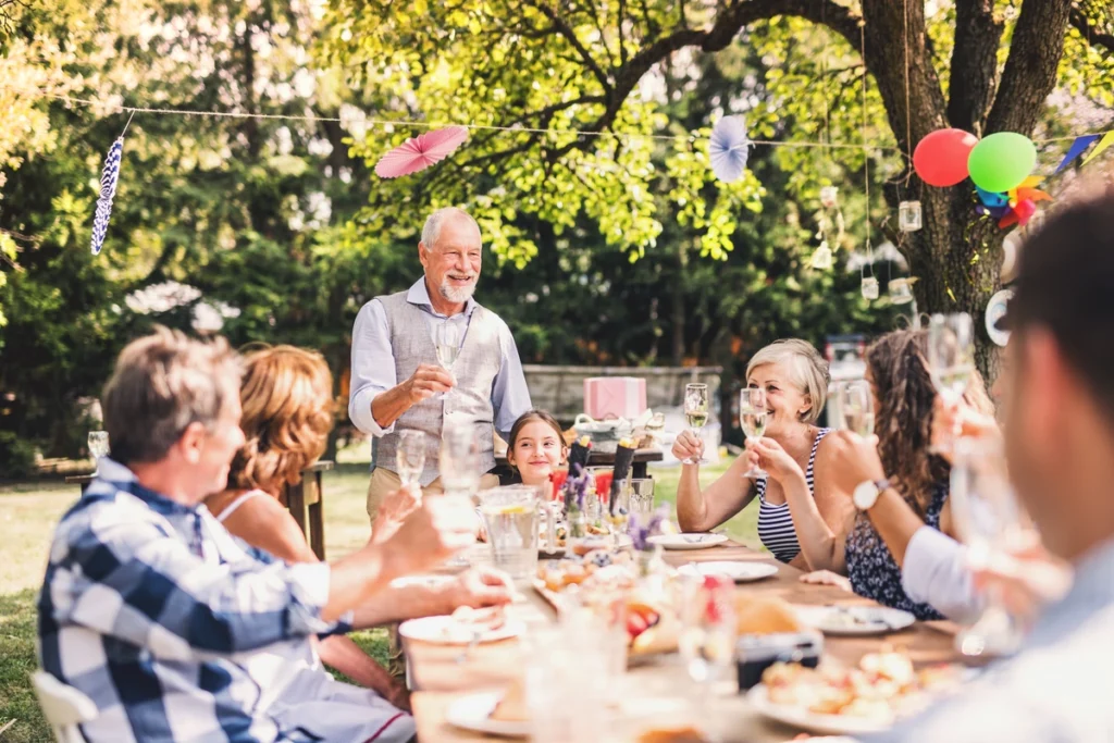 Multigenerational family outside of house with new roof having a garden party