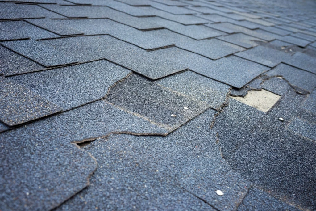 close up of damaged roof shingles before replacement