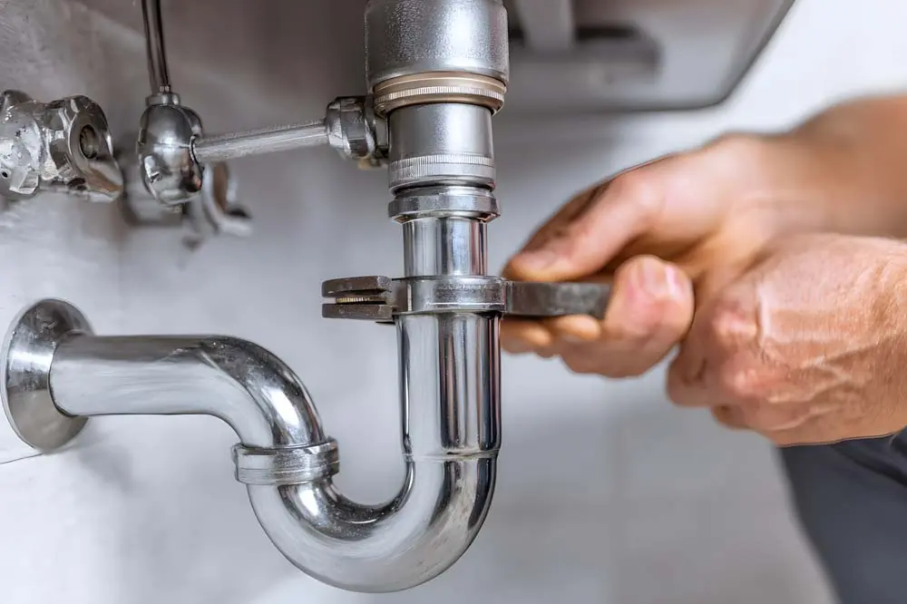 pipe being tightened by a plumber