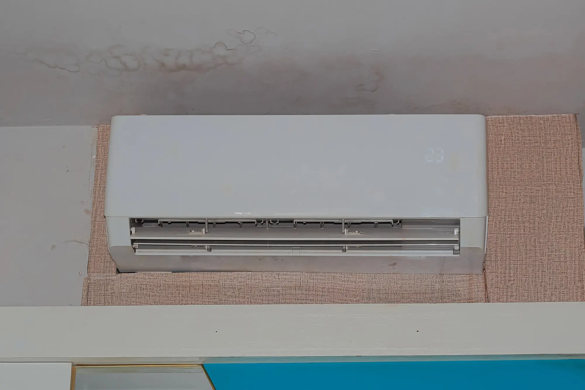 Water stain and dampness on residential ceiling from malfunctioning AC unit