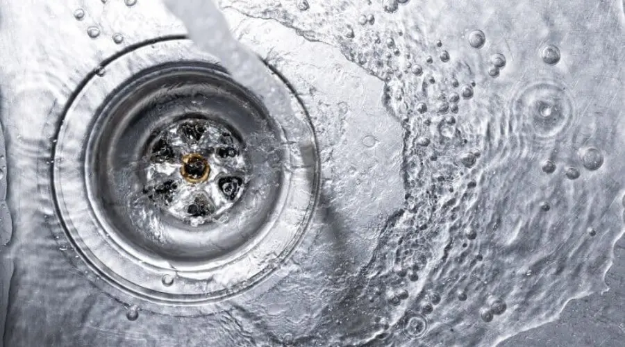 Circular drain with flowing water and ripples, showcasing plumbing elements relevant to Zing Plumbing services.