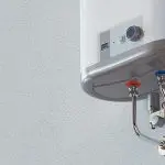 Hot water heater mounted on a white wall with control panel, featuring Allore's Plumbing Services for reliable installations.