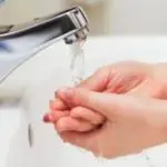 Hands under a clean faucet, washing with flowing water, showcasing plumbing hygiene by Allore's Plumbing Services.