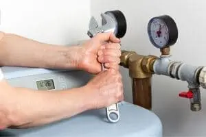 Plumber using a wrench to adjust a water softener system, featuring pressure gauges and plumbing components, emphasizing water treatment and filtration solutions.