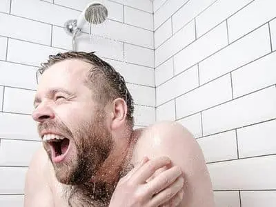 Man in shower enjoying a warm water flow, highlighting the comfort of a functional water heater.