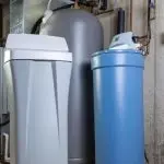 Gray water softener and pressure tank in an industrial basement setting by Allore's Plumbing Services LLC.