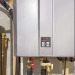 Tankless water heater installation with control panel and plumbing connections, illustrating energy-efficient heating solutions for homes.
