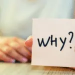 A hand holding a plumbing maintenance card with the word "WHY?" for Allore's Plumbing Services.