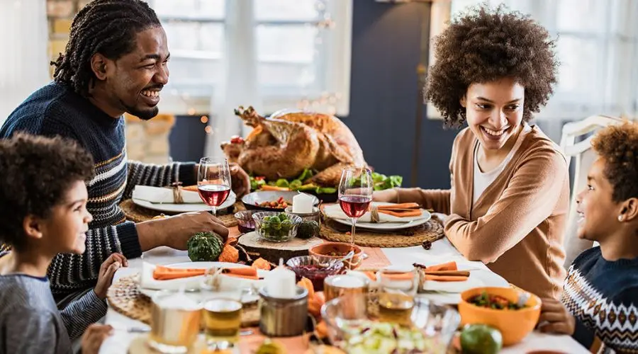 Family gathering at a dining table with food and drinks, reflecting a cozy celebration&mdash;Allore's Plumbing Services LLC.