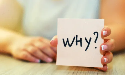 Person holding a card with the word "WHY?" emphasizing the importance of understanding water heater maintenance and repairs.