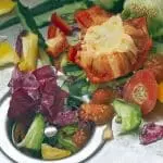 Colorful vegetable scraps and fruit in a sink drain, illustrating food waste in a business context.