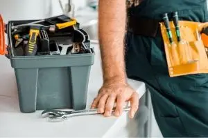 Plumber preparing tools, including a wrench and toolbox, emphasizing the importance of preparation for efficient plumbing services.