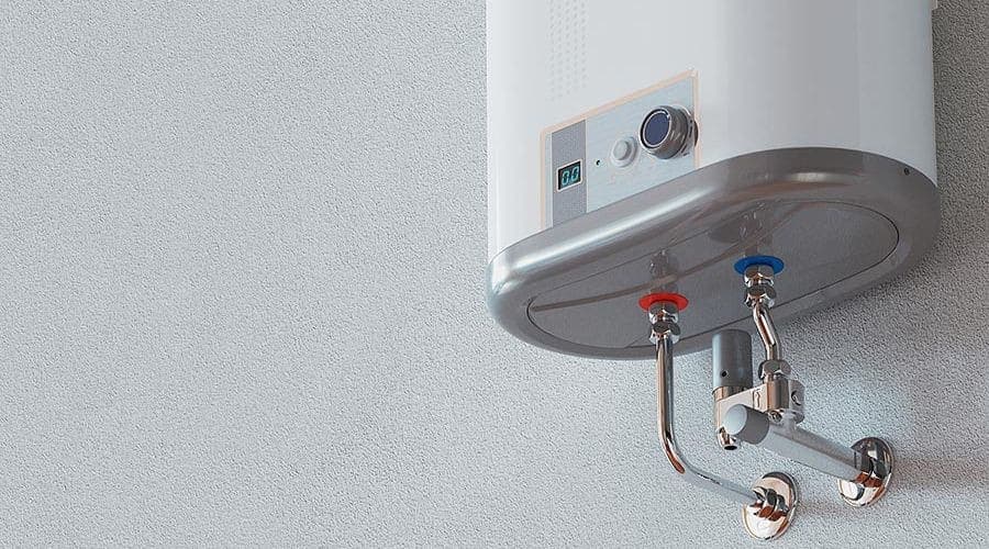 Modern water heater with metallic design, temperature control dial, and digital display mounted on light gray wall.