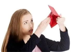 Woman looking concerned while holding an empty red wallet, reflecting financial stress related to unexpected plumbing repairs.