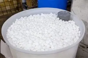 White water softener salt pellets in a large container, essential for maintaining a home water softening system to combat hard water issues.