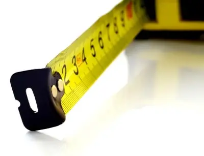 Measuring tape illustrating scale and size differences in plumbing systems for commercial versus residential buildings.