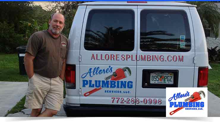 Man standing beside Allore's Plumbing service van, featuring logo and contact information, in a residential setting.