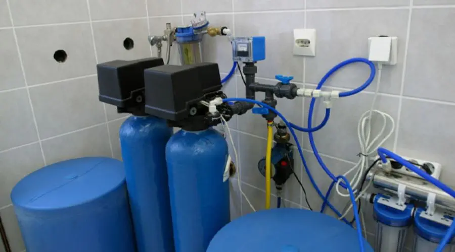 Water treatment equipment featuring blue tanks and filtration system&mdash;Allore's Plumbing Services LLC.