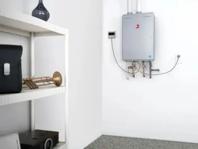 Tankless water heater mounted on wall in a modern interior, showcasing space-saving design and energy efficiency, relevant to plumbing services and home utility savings.