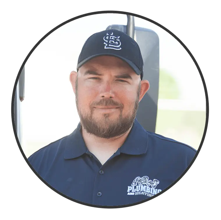 Man with a beard wearing a baseball cap and a navy shirt with "A&W Plumbing and Heating" logo, smiling confidently, representing the dedicated team at A & W Plumbing and Heating, Inc.