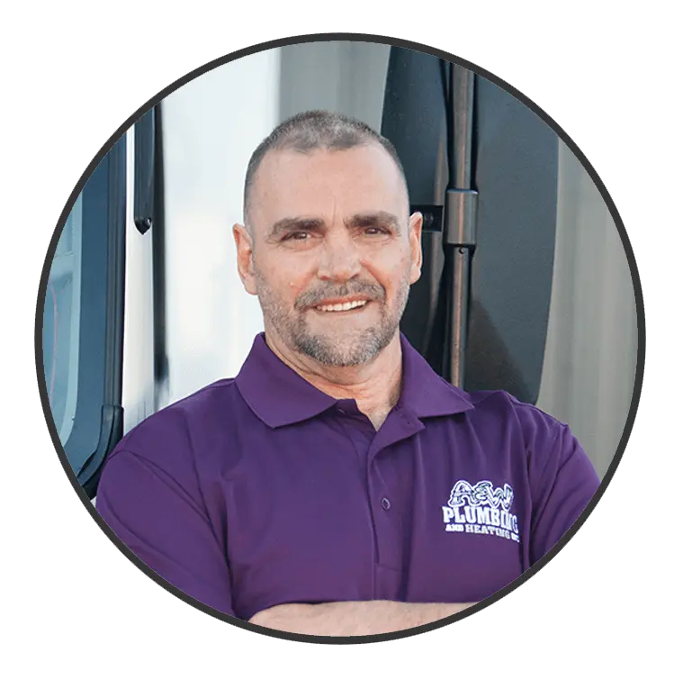 Plumber from A & W Plumbing and Heating, Inc. wearing purple uniform, smiling, standing next to a truck.