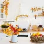 Autumn-themed kitchen with fruit bowl and utensils; A & W Plumbing shares garbage disposal maintenance tips.