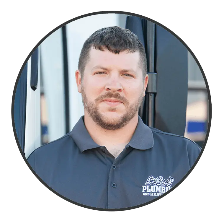 Plumber from A & W Plumbing and Heating, Inc. wearing a branded polo shirt, standing in front of a service vehicle, showcasing professionalism and expertise.