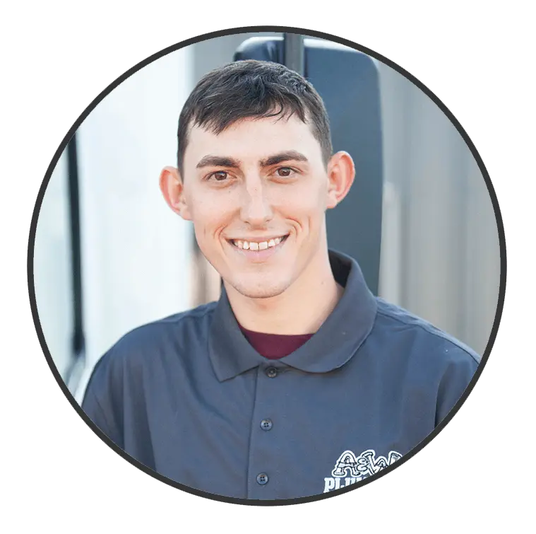 Smiling plumber in a gray uniform representing A & W Plumbing and Heating, showcasing professionalism and friendly service.