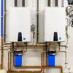 Two modern water heaters with digital displays and copper pipes by A & W Plumbing and Heating, Inc.