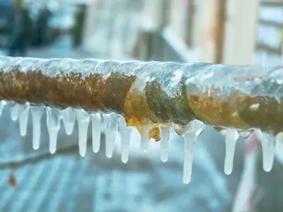 Frozen pipe with icicles hanging from it, illustrating the dangers of uninsulated plumbing during winter months, emphasizing the importance of pipe insulation to prevent frozen and burst pipes.