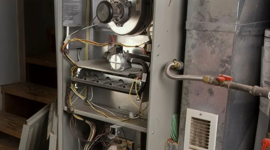 Furnace interior showing components such as blower motor, gas valve, and wiring, illustrating heating system maintenance and repair context.