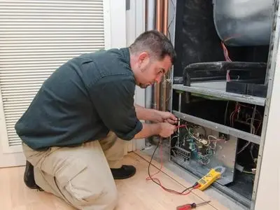 HVAC technician performing maintenance on heating equipment, ensuring reliable climate control for winter comfort.